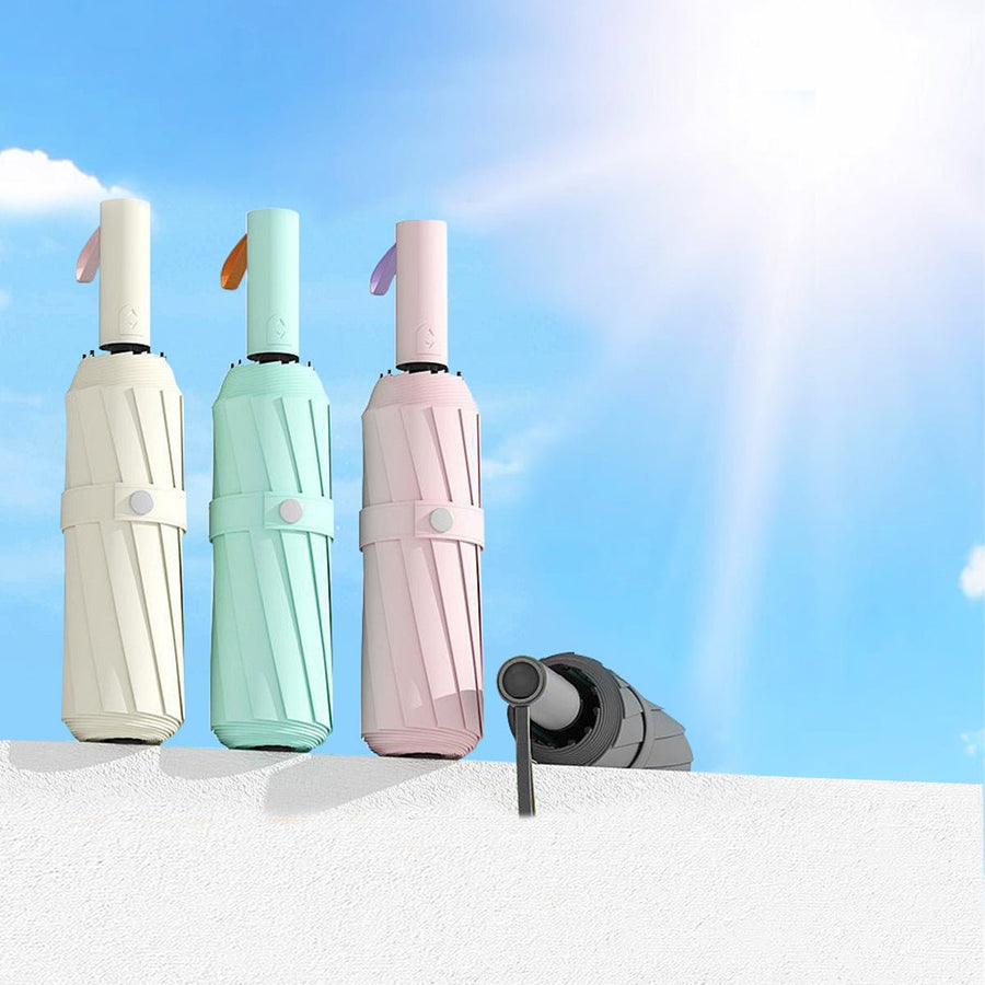 Three compact umbrellas in white, green, and pink with a blue sky and rainbow background.