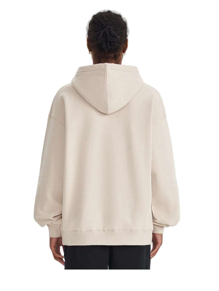 Person wearing a beige hoodie from behind on a light gray background