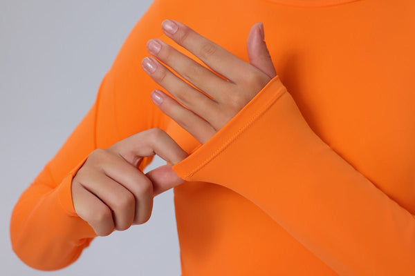 Person wearing an orange sweatshirt with a plain background