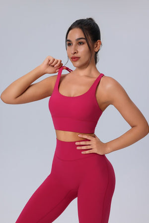 Woman wearing a #pink sports bra and leggings on a gray background