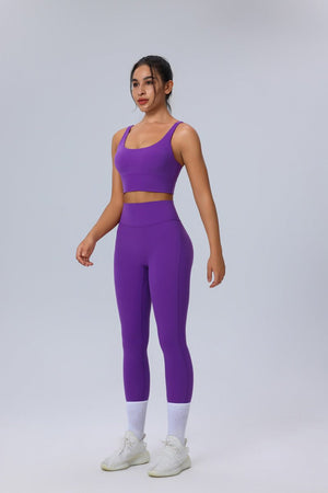 Woman wearing a #purple athletic outfit on a light gray background