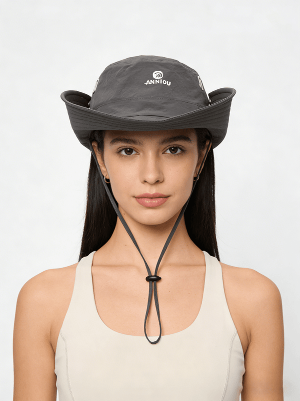 Woman wearing a gray wide-brimmed hat with a brand logo on a white background