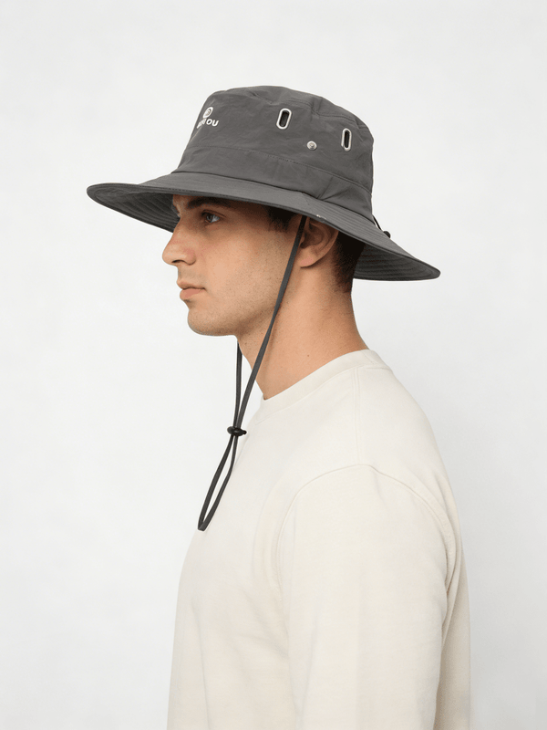 Person wearing a gray bucket hat with a white background