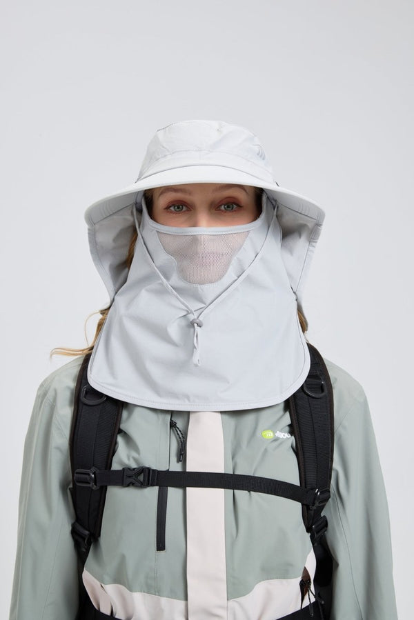 Person wearing a light gray hooded jacket with a face covering on a white background