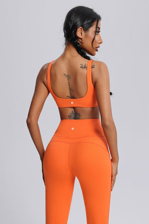 Woman wearing an #orange front twist  sports bra and leggings by Anniou