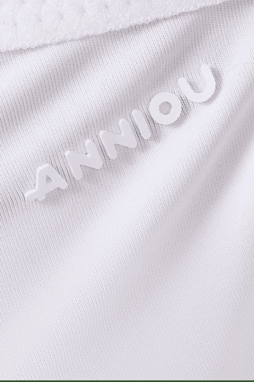 Close-up of a white fabric with 'ANNIOU' branding.