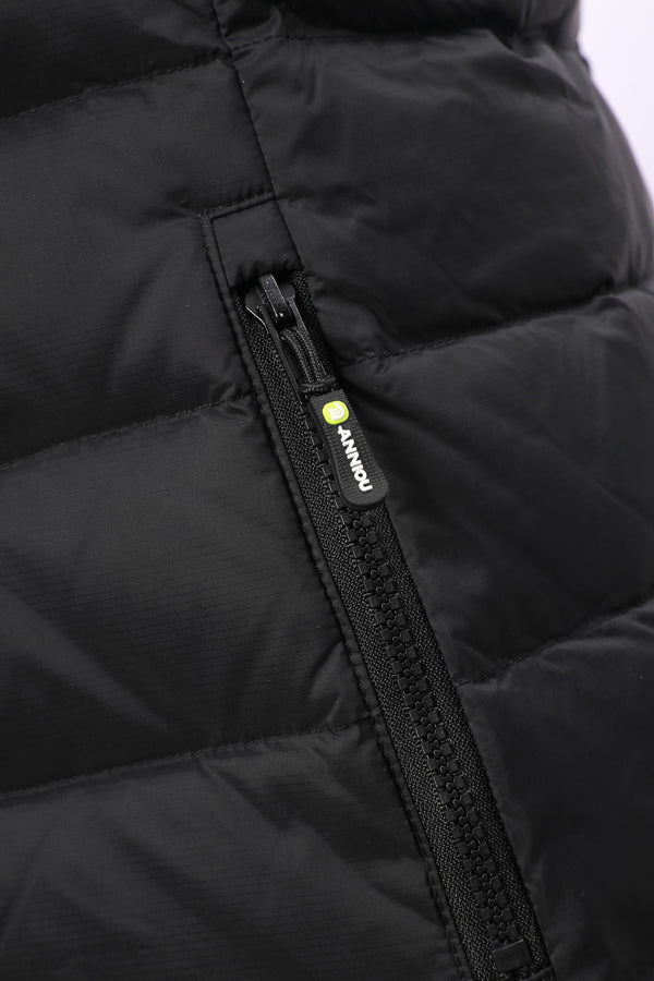 Close-up of a black puffer jacket showing a quilted panel and a black zipper with a small yellow-green brand tab reading ANNIOU.