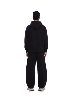 Back view of a male model wearing a #black waffle hoodie and matching wide sweatpants against a plain white background.