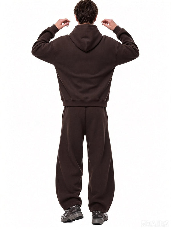 A male model stands in back view with hands raised near his hood, wearing a #coffee waffle-knit hoodie and matching wide sweatpants against a plain white background.