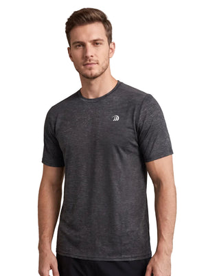 A front-view studio portrait of a man wearing a dark heather gray athletic T-shirt with a small white logo on the left chest, standing against a plain neutral background.