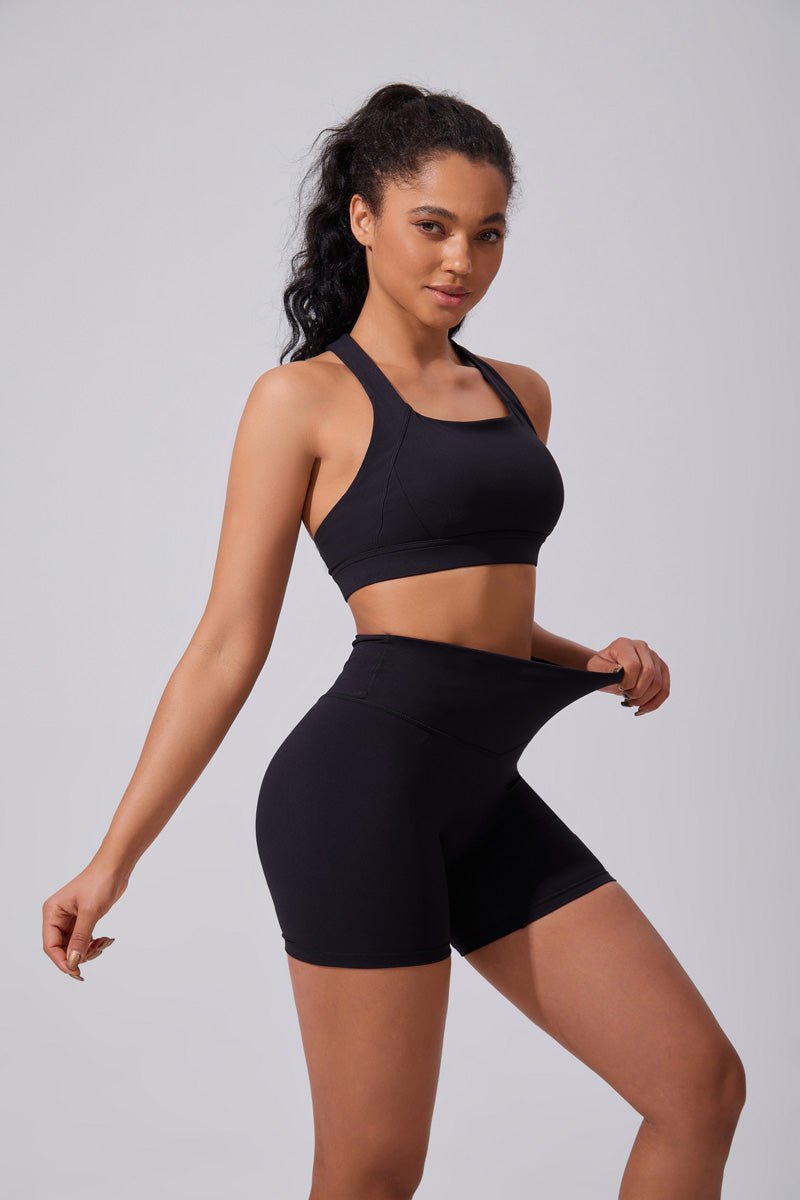 Woman wearing a black sports bra and shorts  UPF 50+