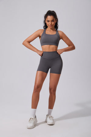 Woman wearing a #gray athletic outfit on a plain background
