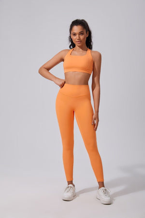 Woman wearing an #orange athletic outfit on a light gray background