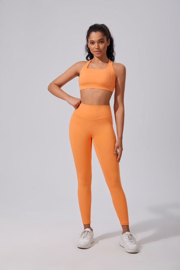 Woman wearing an #orange athletic outfit on a light gray background