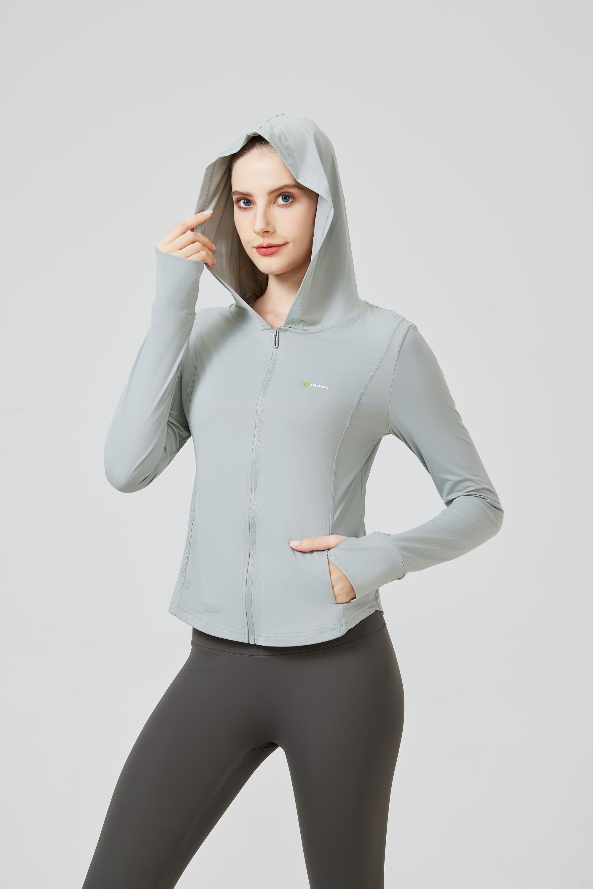 Person wearing a light gray hoodie and dark gray leggings on a white  background Anniou UPF 100 