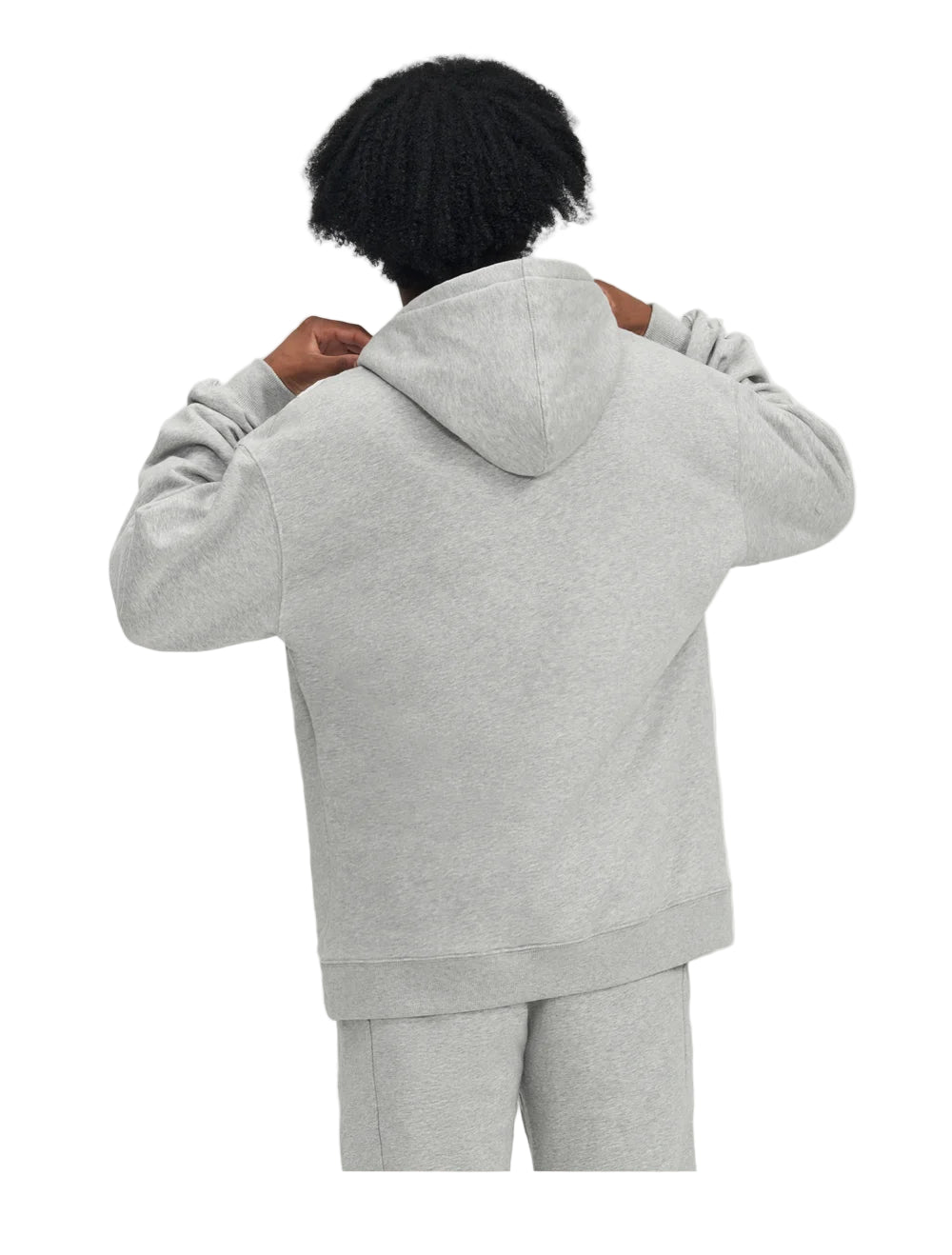Person wearing a gray hoodie and pants on a light gray background