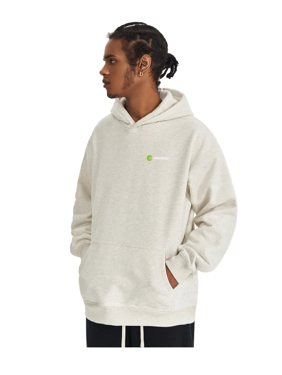 Person wearing a beige hoodie with a logo on a light background