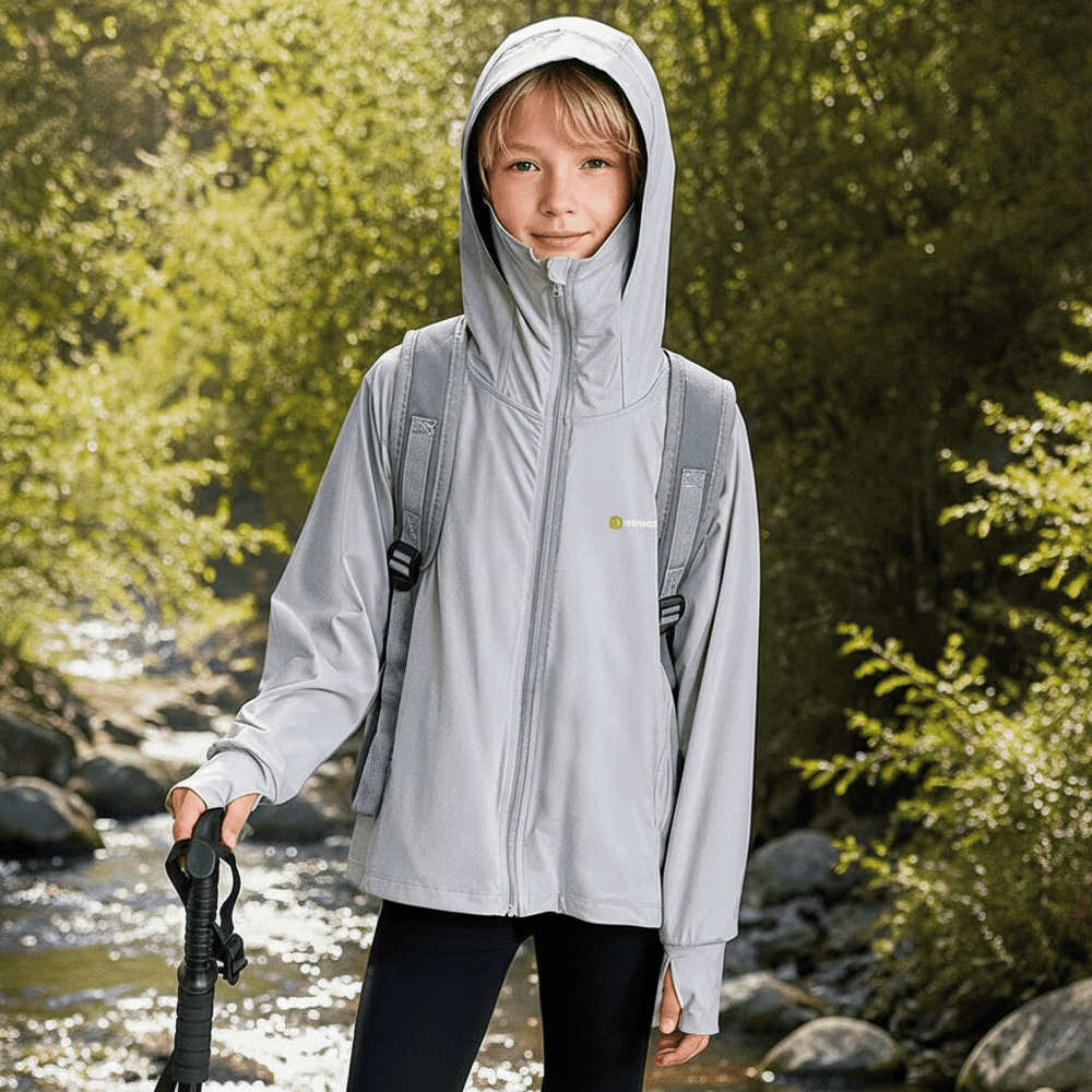 The little boy was exploring outdoors wearing a gray hooded sun protection jacket