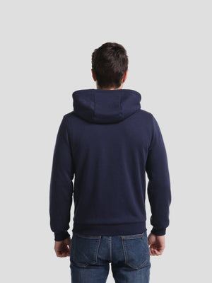 Person wearing a navy blue hoodie on a light gray background