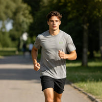 A man wearing a gray quick-drying T-shirt is jogging in the park.