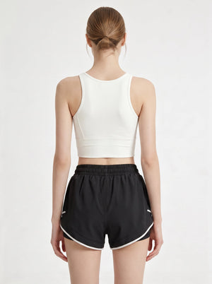 A woman shows the back of her athletic shorts in a photography studio.