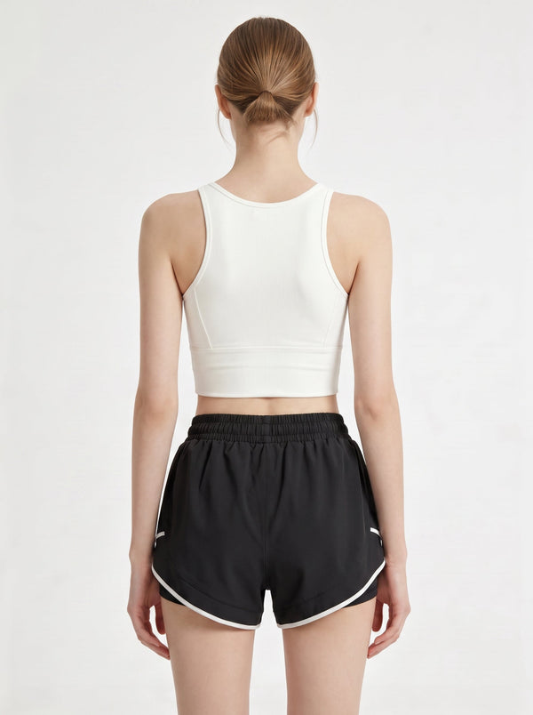 A woman shows the back of her athletic shorts in a photography studio.
