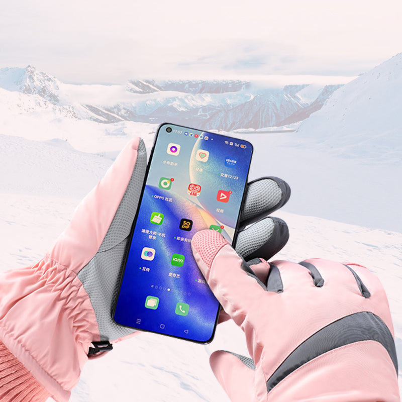 Person using a smartphone with touchscreen gloves in a snowy landscape
