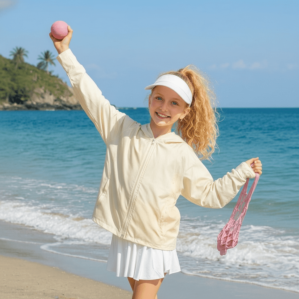 The little girl was playing on the beach wearing a beige sun-protective shirt