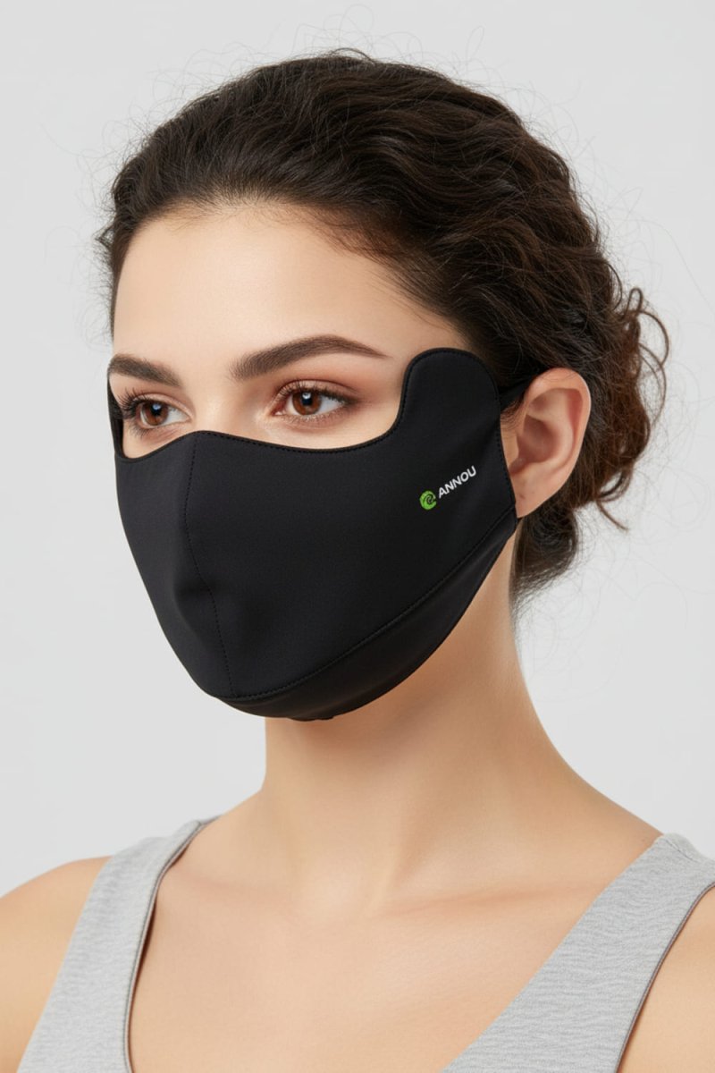 Woman wearing a black face mask with a Anniou logo on a light gray background