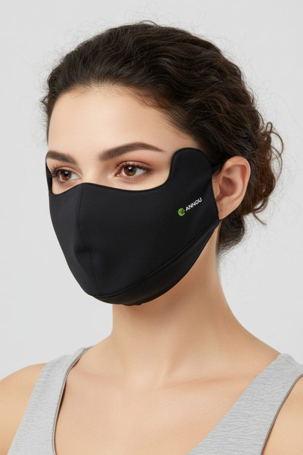 Woman wearing a black face mask with a Anniou logo on a light gray background