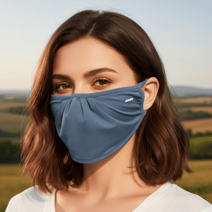 Woman wearing a blue face mask with a blurred natural landscape in the background UPF 50+