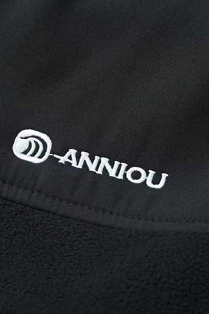 Close-up of a black fabric with 'Anniou' logo embroidered on it.
