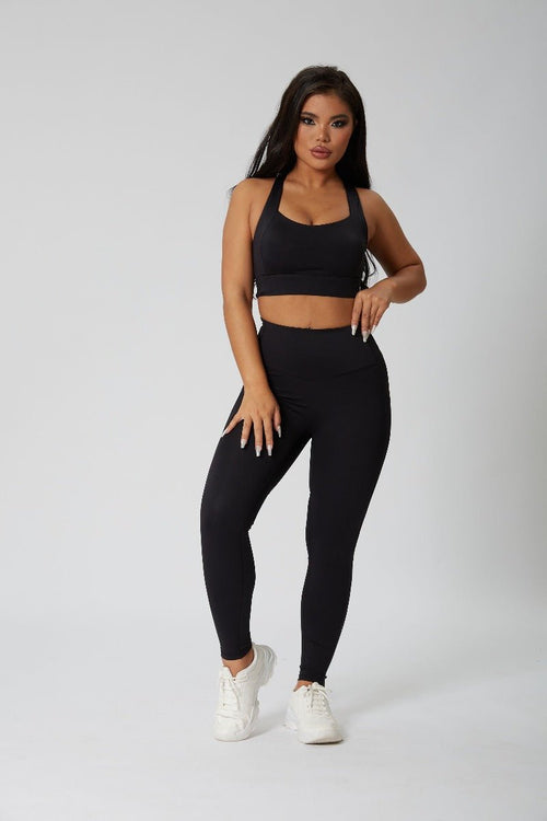 Woman wearing a #black sports bra and slim yoga leggings 