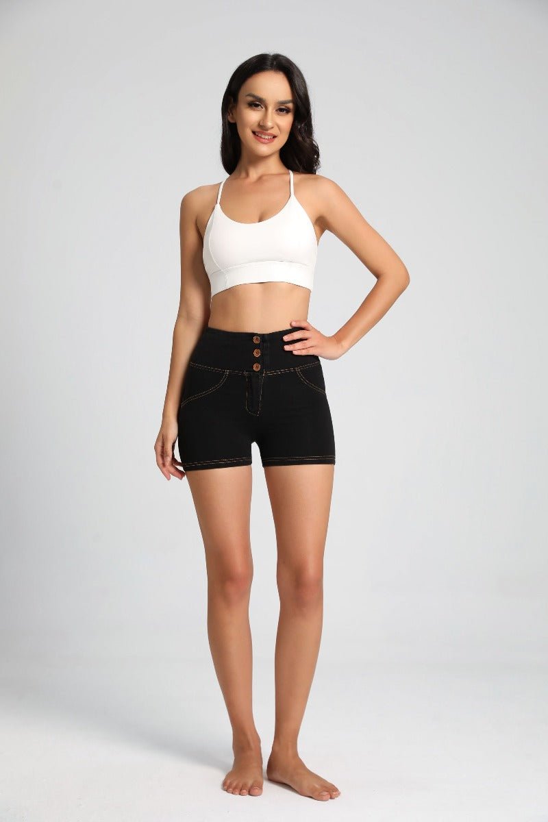 Woman wearing a white tank top and #black shorts on a gray background