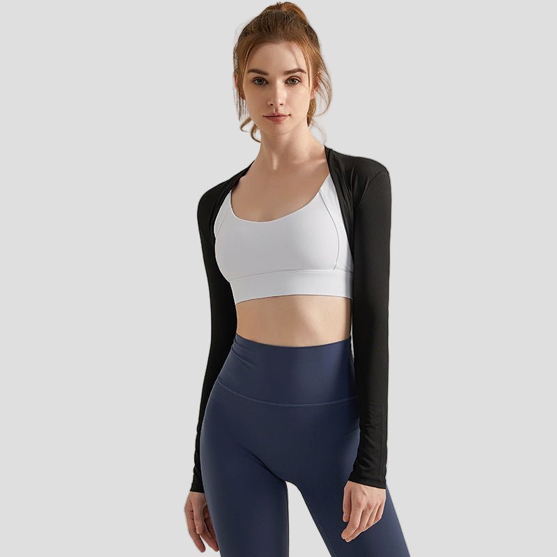 Woman wearing a black long-sleeve Sun Protection Cooling Arm Wrap, white sports bra, and blue leggings on a light gray background