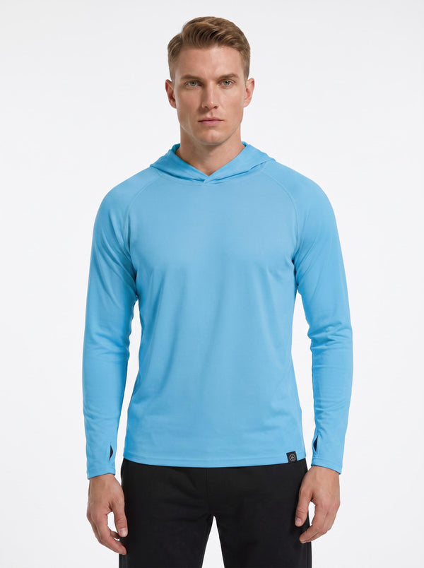 A male model wearing a # blue hooded long-sleeve performance shirt and black athletic pants stands against a plain white background. 