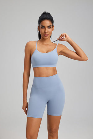 Woman wearing a light #blue sports bra and high-waisted shorts