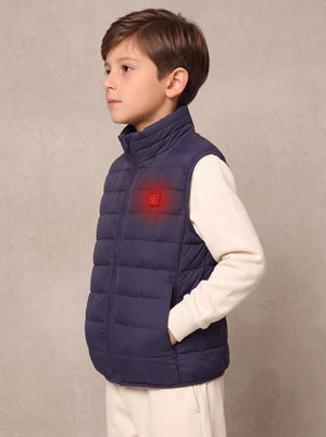 A young boy wearing a navy blue quilted puffer vest over a cream long-sleeve shirt, 