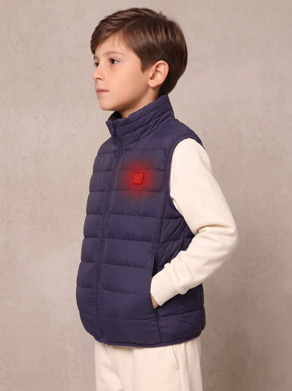 A young boy wearing a navy blue quilted puffer vest over a cream long-sleeve shirt, 