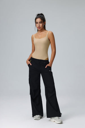 Woman wearing a #clay tank top and black cargo pants