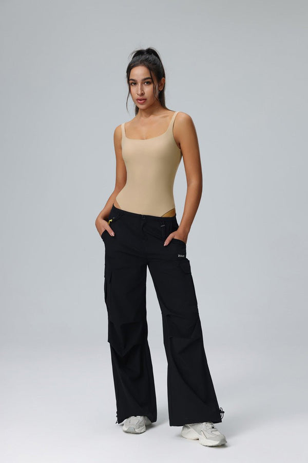 Woman wearing a #clay tank top and black cargo pants