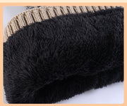 Close-up of black textured fabric with a beige and brown striped pattern hat  in the background.