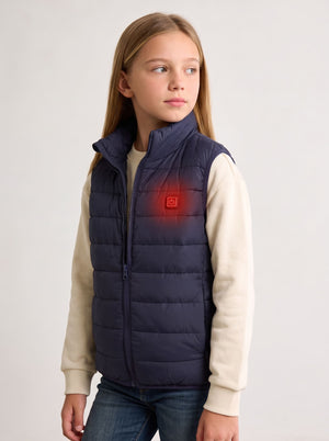 A young girl wearing a navy blue insulated heated puffer vest with a built-in heating element on the chest