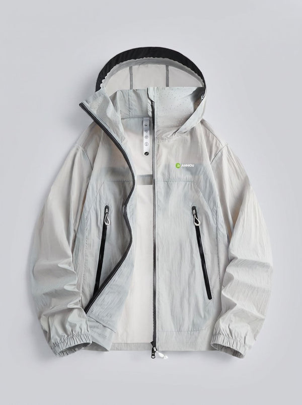 A light gray hooded windbreaker jacket with black zipper details and a small green and white logo on the left chest, displayed flat against a light gray background.