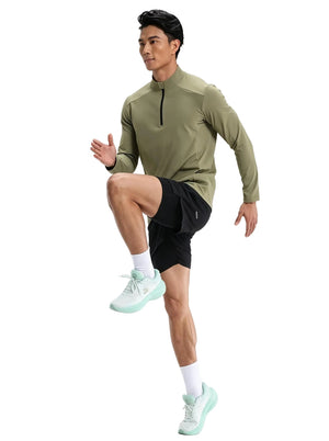Male model doing high knees in #green half-zip long sleeve sport top, black shorts and mint running shoes, plain white studio background