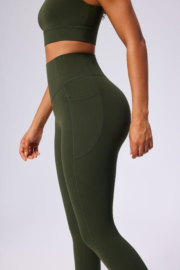 Person wearing #green athletic leggings and crop top on a light gray background