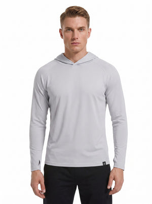 A male model wearing a #grey hooded long-sleeve performance shirt and black athletic pants stands against a plain white background. 