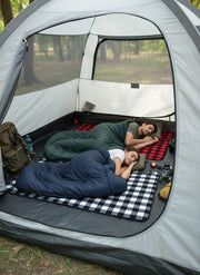 two people sleeping on a check heated mat