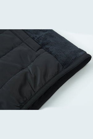 Black quilted jacket on a white background