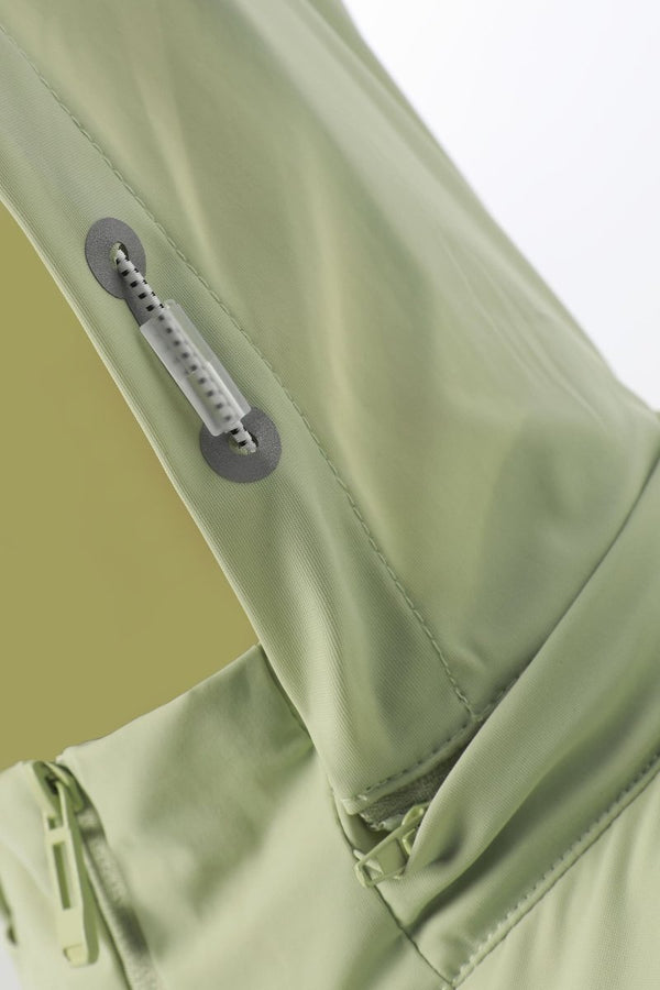 Close-up of a green jacket with zippers on a light gray background
